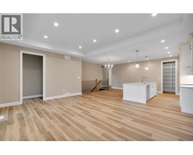 A spacious room with wooden flooring and a white cabinet in the corner.