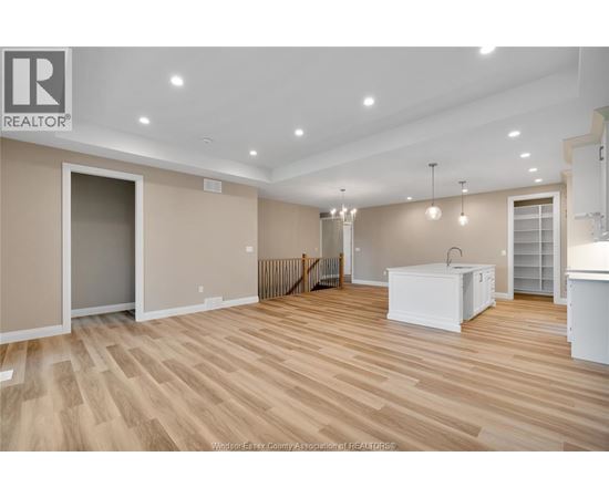 A spacious room with wooden flooring and a white cabinet in the corner.