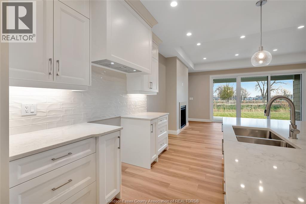 A modern kitchen with white cabinets and a marble countertop.