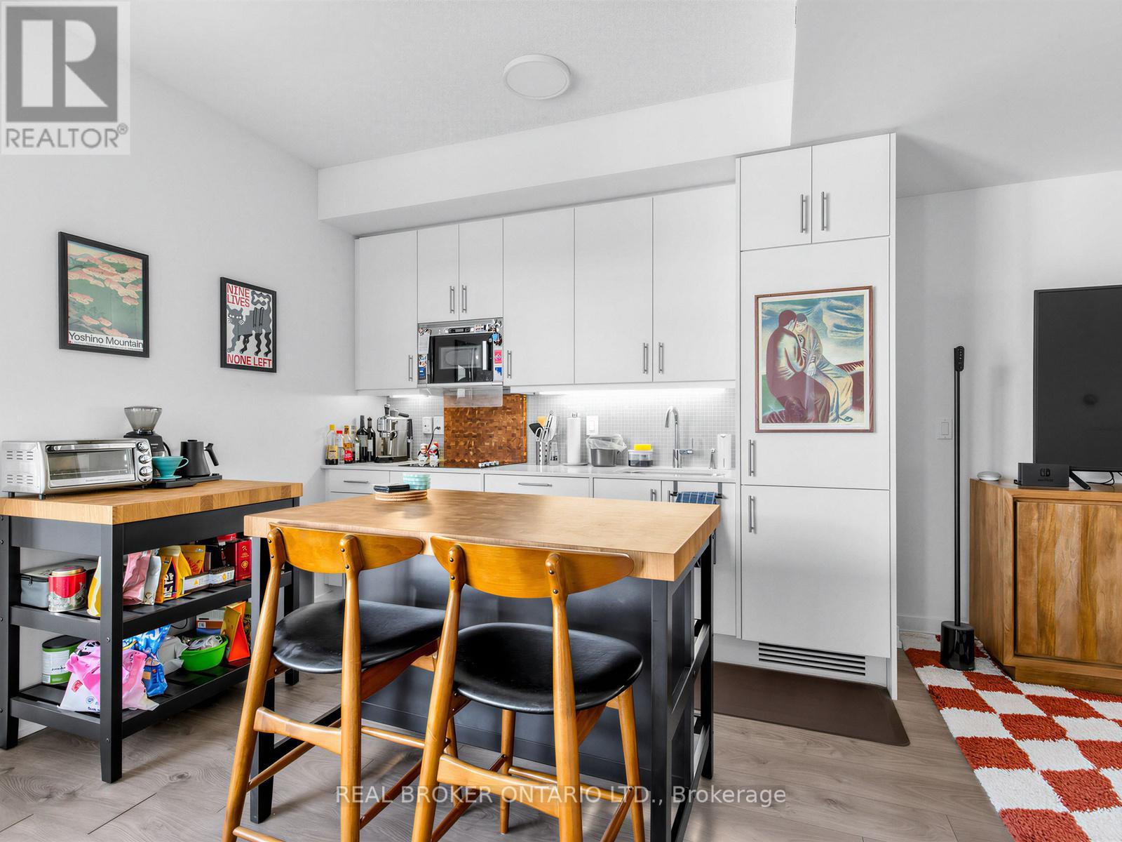 A kitchen with a table and chairs in the middle.