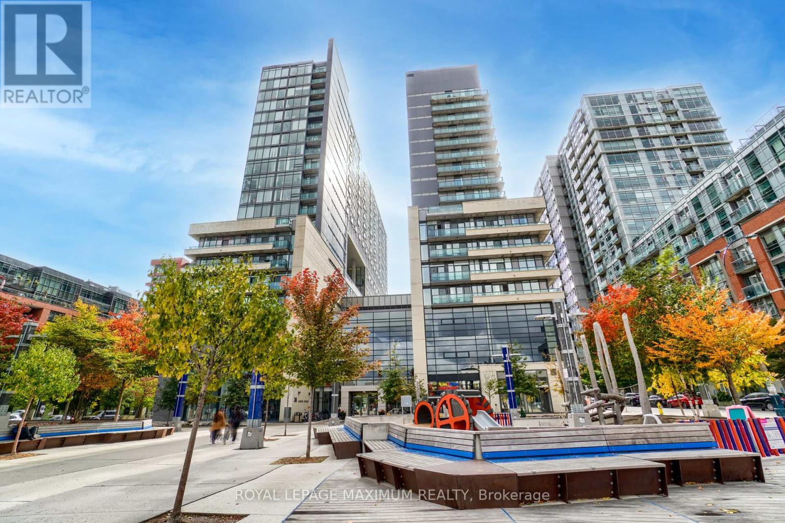 A tall building with a glass facade and a sign that reads "REALTOR" in the foreground.