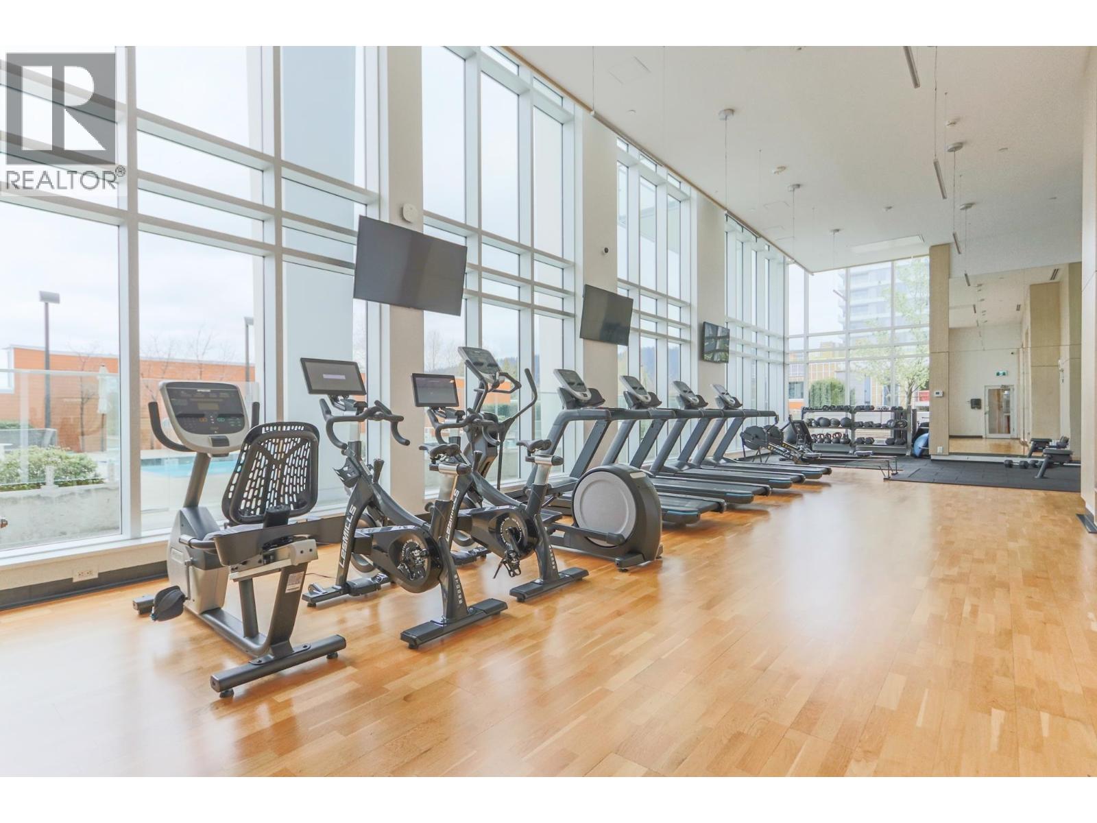 A gym with a row of exercise bikes and a sign that says "REALTOR".