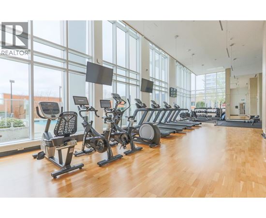 A gym with a row of exercise bikes and a sign that says "REALTOR".