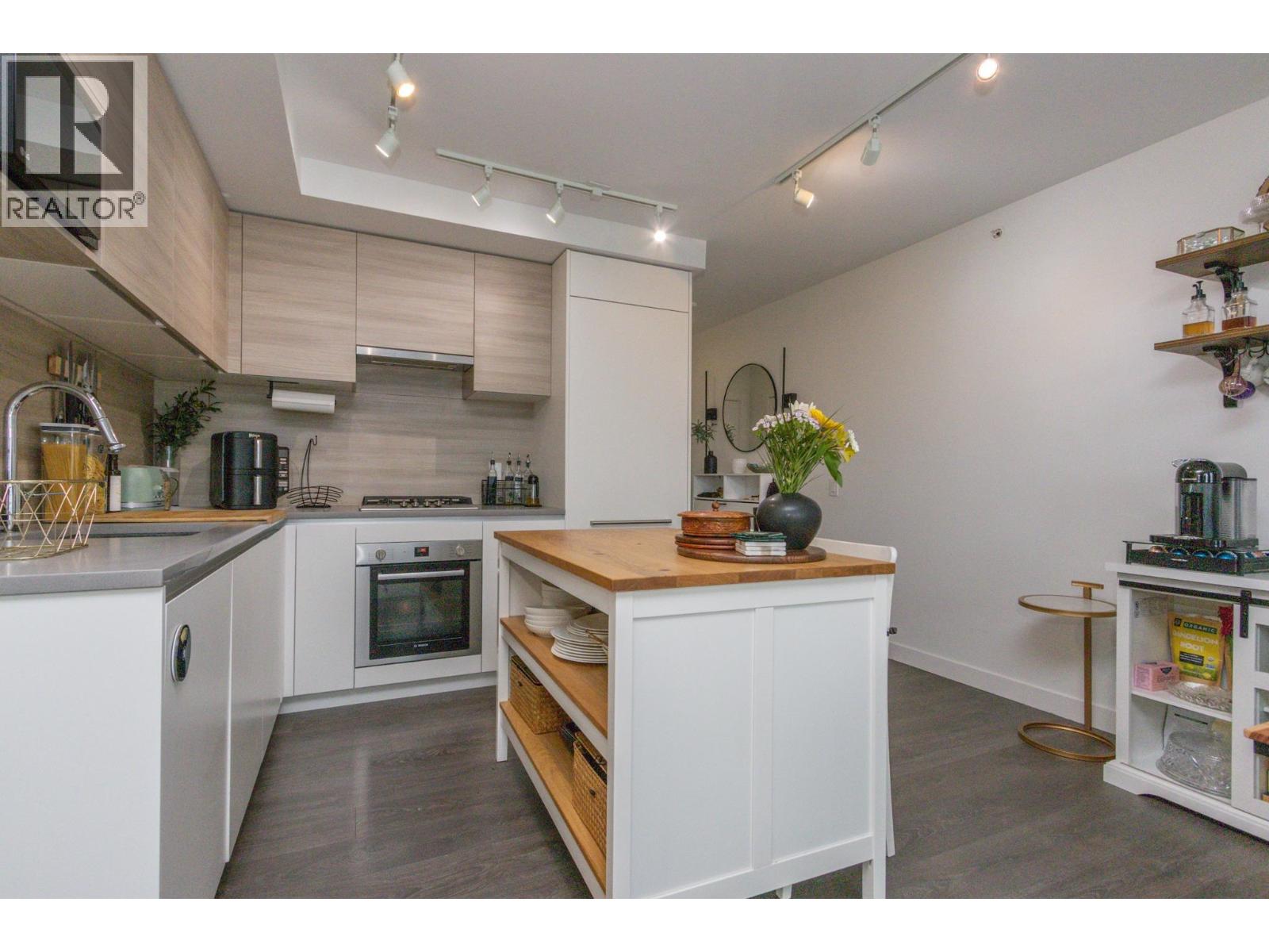A modern kitchen with white cabinets and a wooden island.