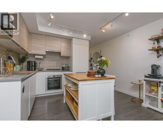 A modern kitchen with white cabinets and a wooden island.