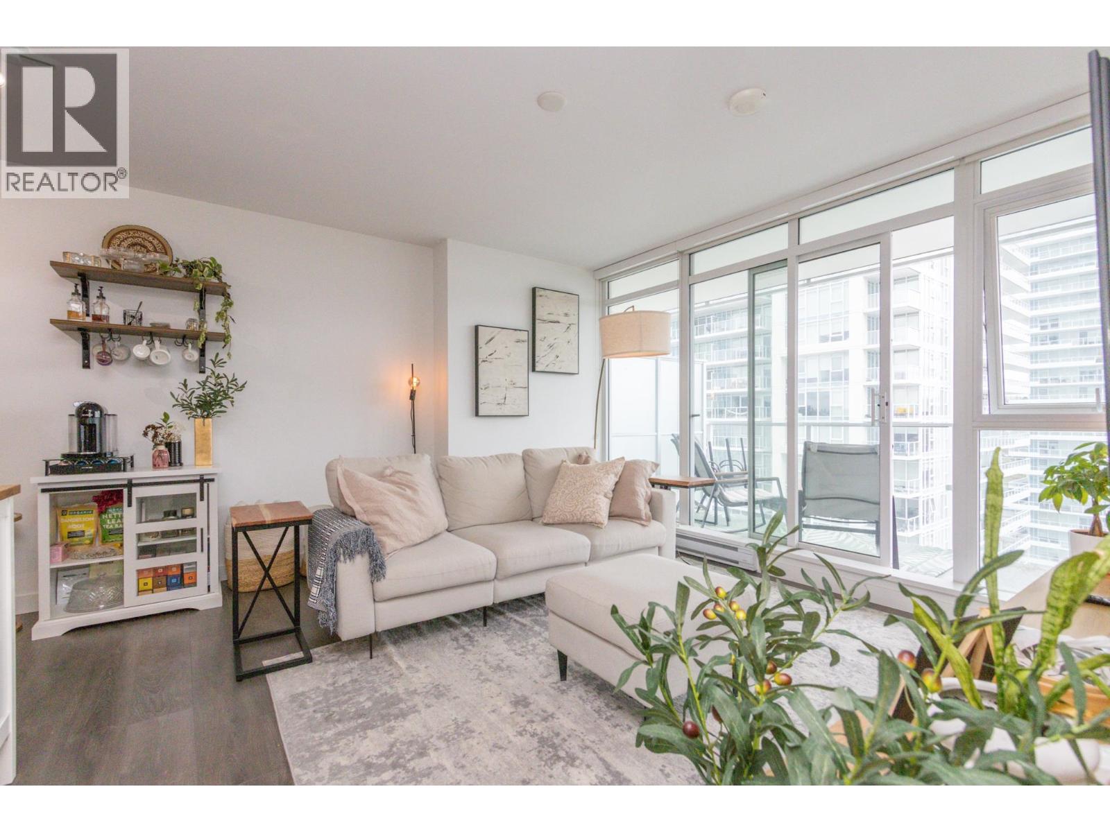 A living room with a white couch and a large window.
