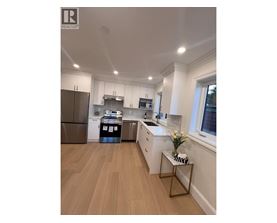 A modern kitchen with wooden floors and white walls.