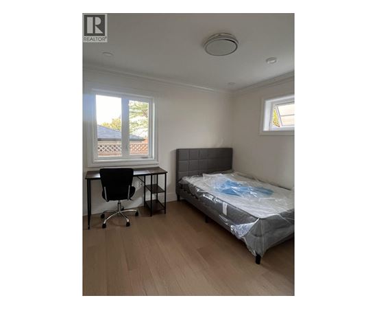 A bedroom with a bed, desk, and chair.