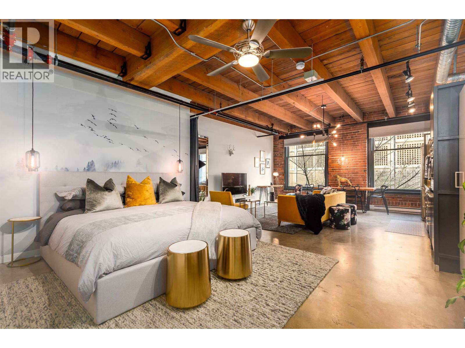 A bedroom with a large bed and a grey rug.