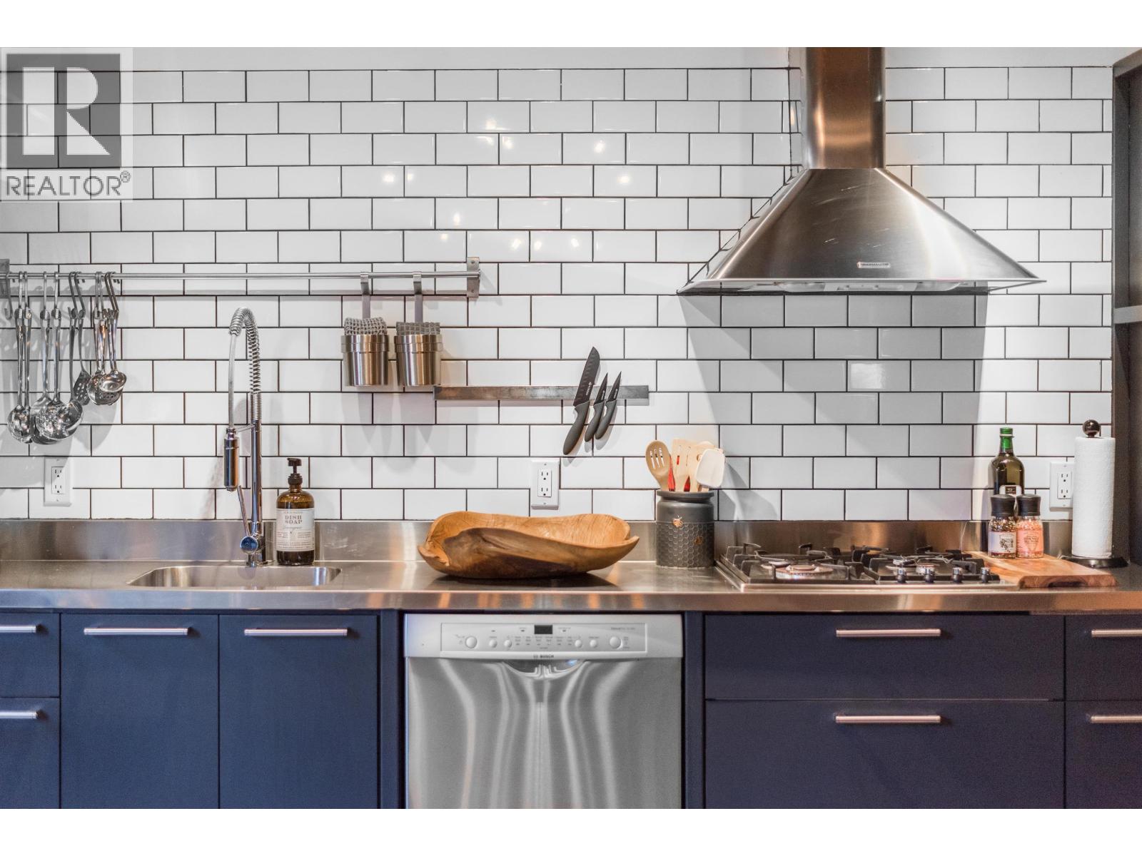 A kitchen with blue cabinets and a stainless steel counter.