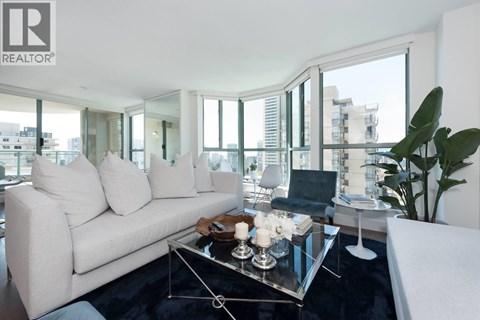 A modern living room with a glass table and a white sofa.
