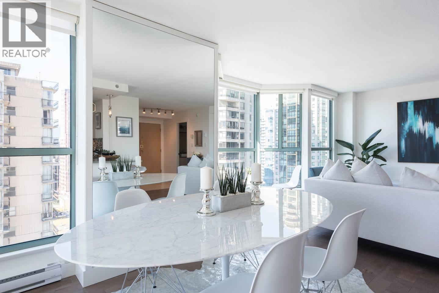 A white dining table with chairs and a plant on it.