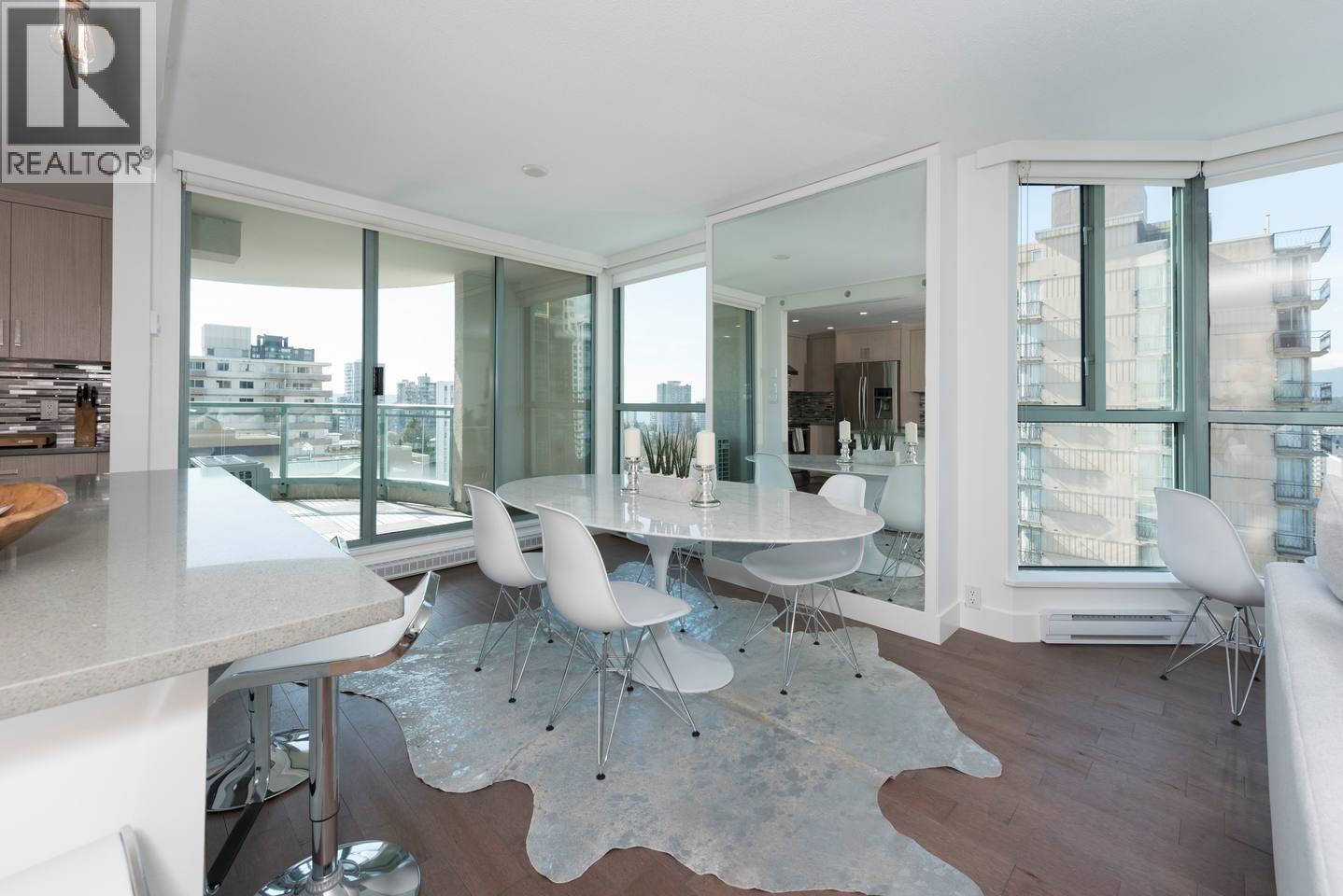 A modern dining room with a glass table and chairs.