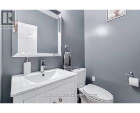 A bathroom with a white sink and toilet.