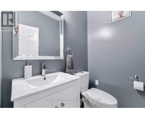 A bathroom with a white sink and toilet.