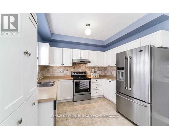 A kitchen with a stove top oven and a refrigerator.