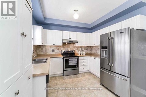 A kitchen with a stove top oven and a refrigerator.