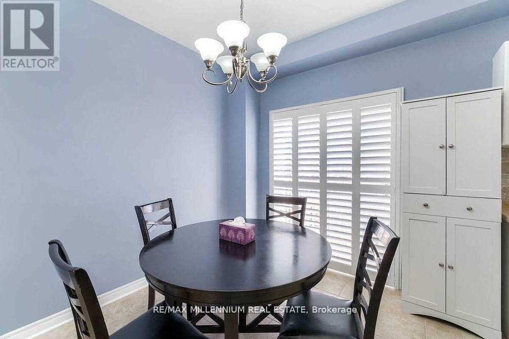 A dining room with a round table and chairs.