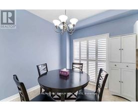 A dining room with a round table and chairs.