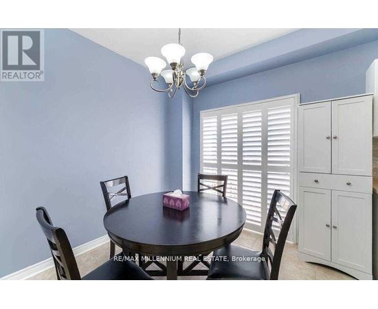 A dining room with a round table and chairs.
