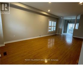 A spacious room with wooden flooring and a window.