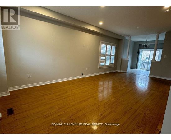 A spacious room with wooden flooring and a window.