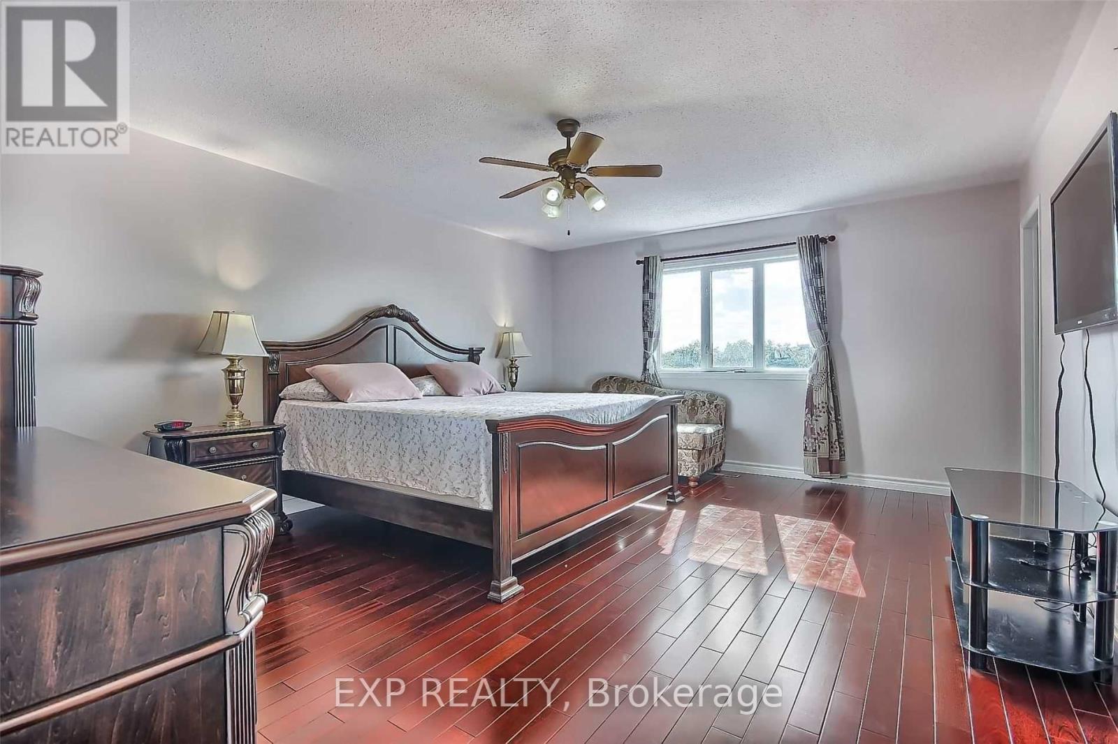 A bedroom with a large bed and a ceiling fan.