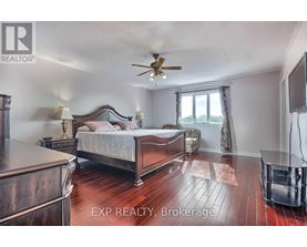 A bedroom with a large bed and a ceiling fan.