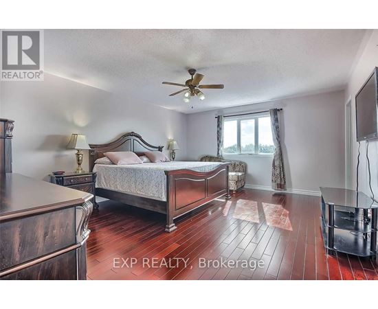 A bedroom with a large bed and a ceiling fan.