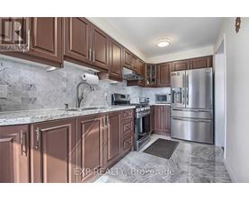 A kitchen with brown cabinets and a marble countertop.