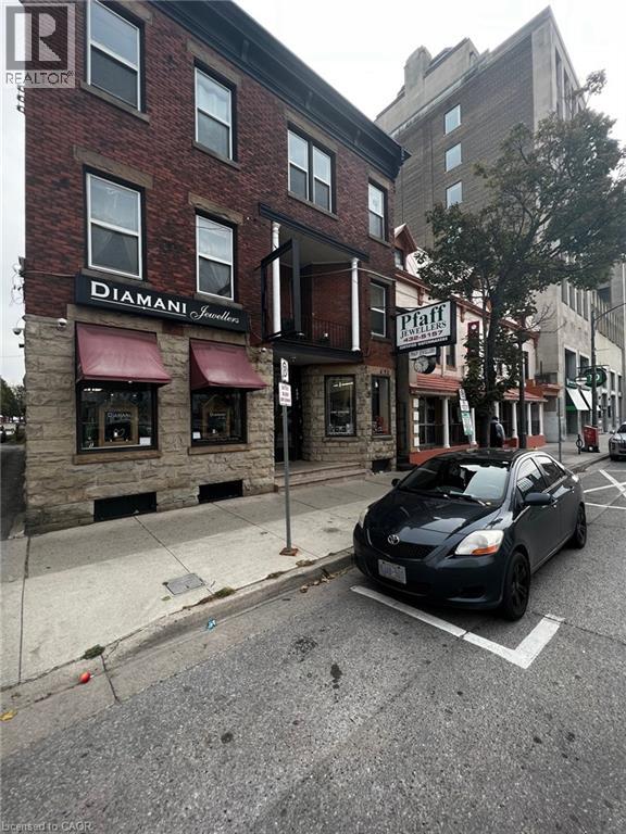A black car is parked on the side of a street.