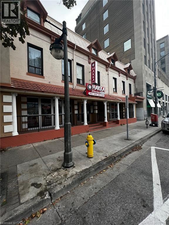 A street view of a building with a red roof and a sign that says "HAKKA".