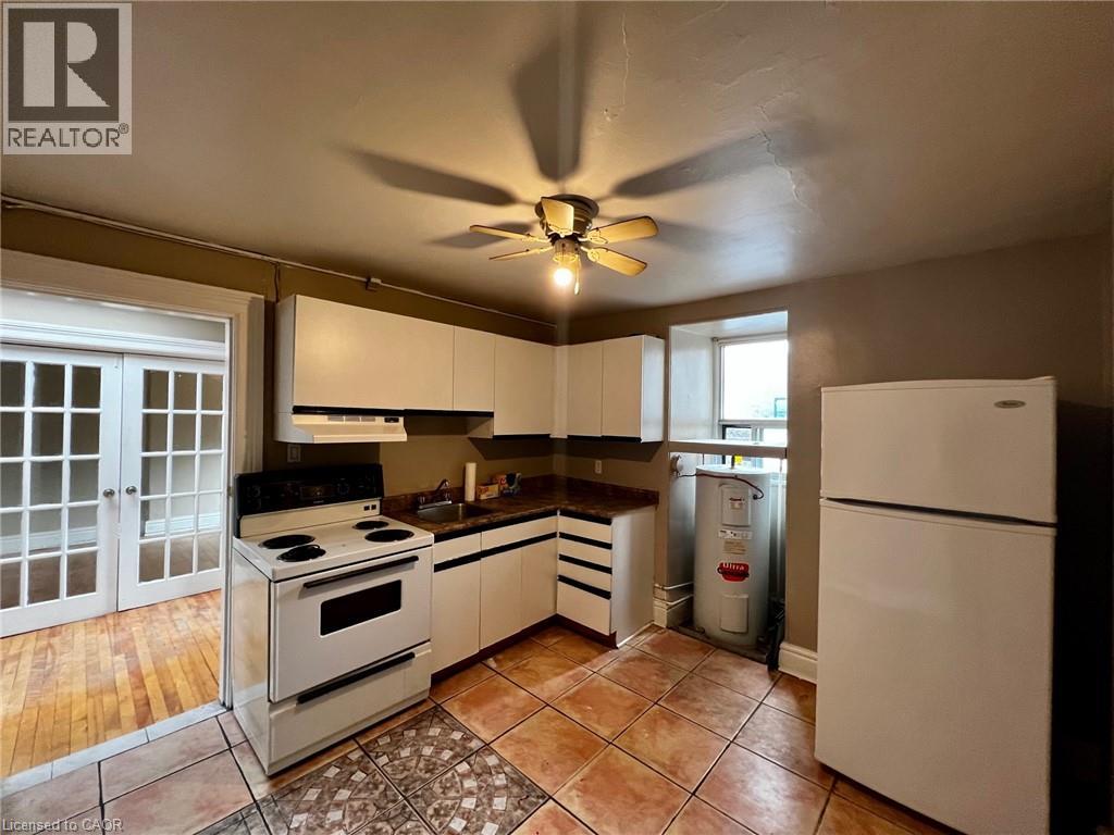 A kitchen with a white refrigerator, white cabinets, and a white stove top oven.