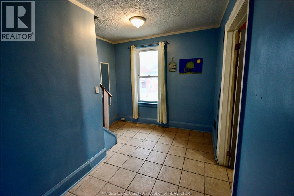 A room with blue walls and a window with white curtains.