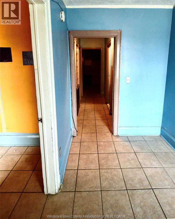 A hallway with a door on the left and a wall on the right.