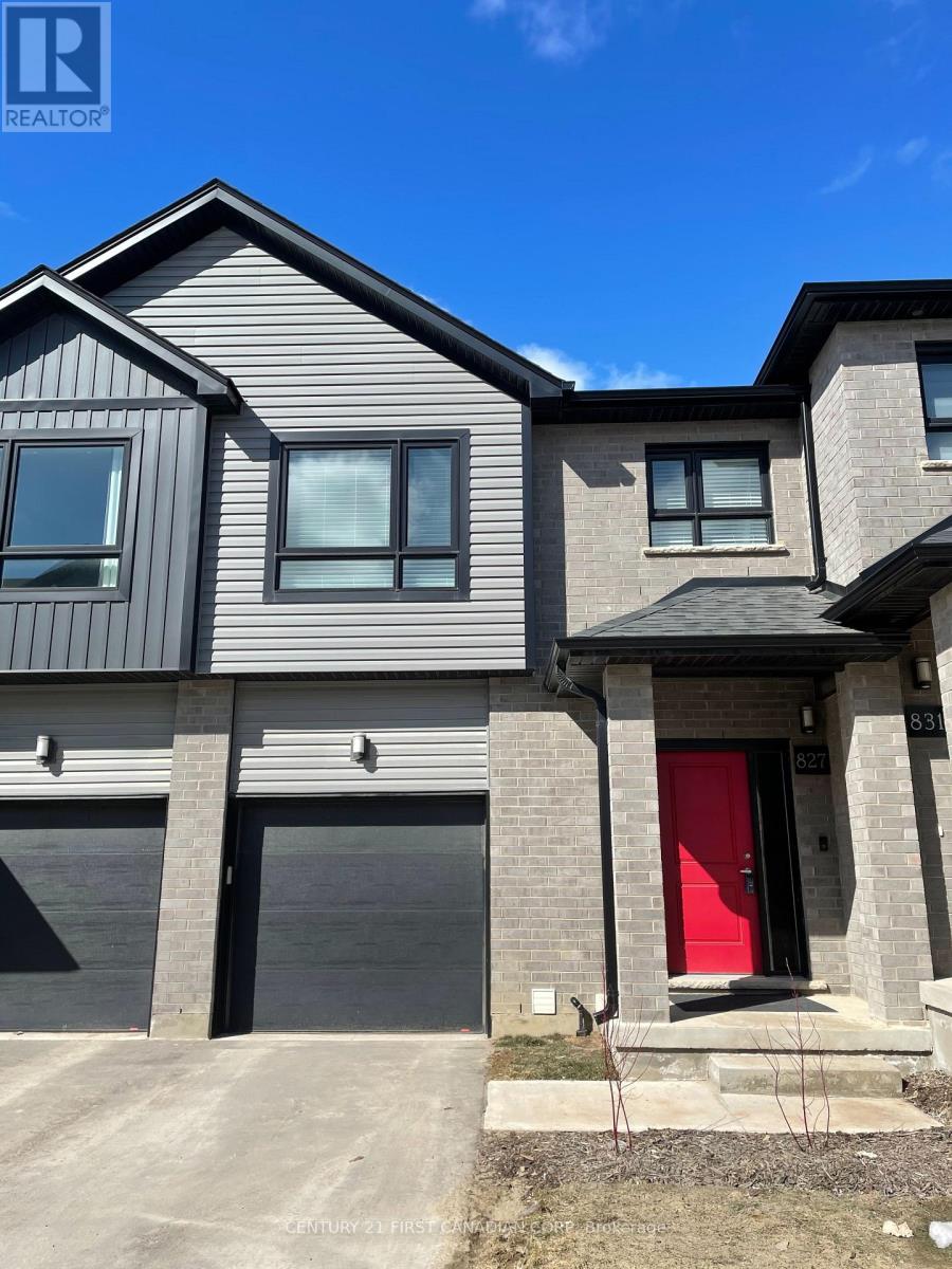 A modern house with a red door is for sale.