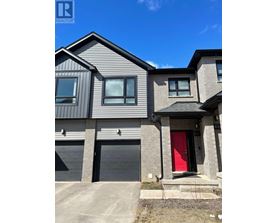 A modern house with a red door is for sale.