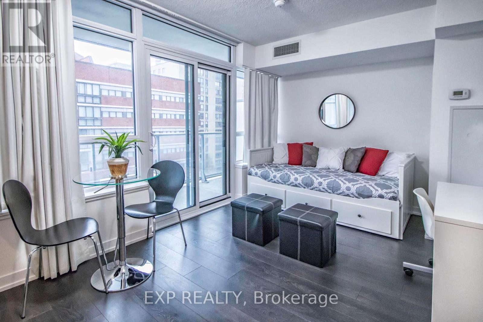A bedroom with a bed, chair, and window.