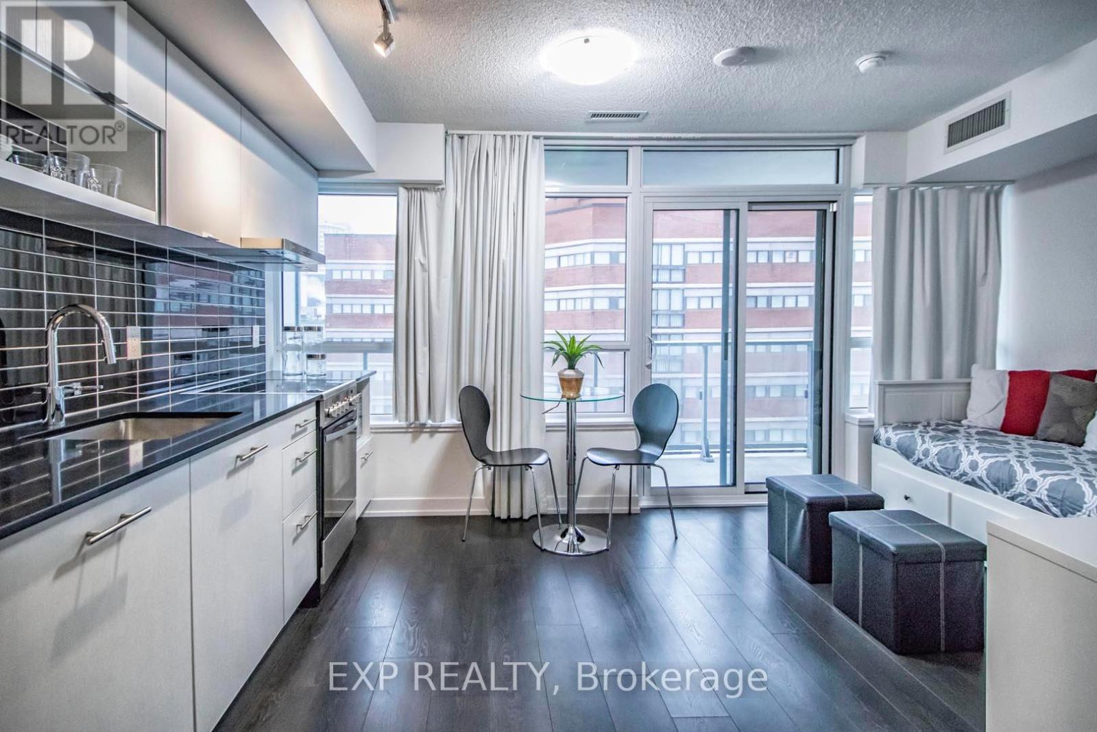A modern kitchen with a dining area and a bedroom in the same space.