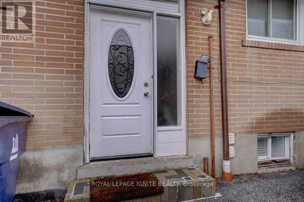 A white door with a glass window is on a brick house.