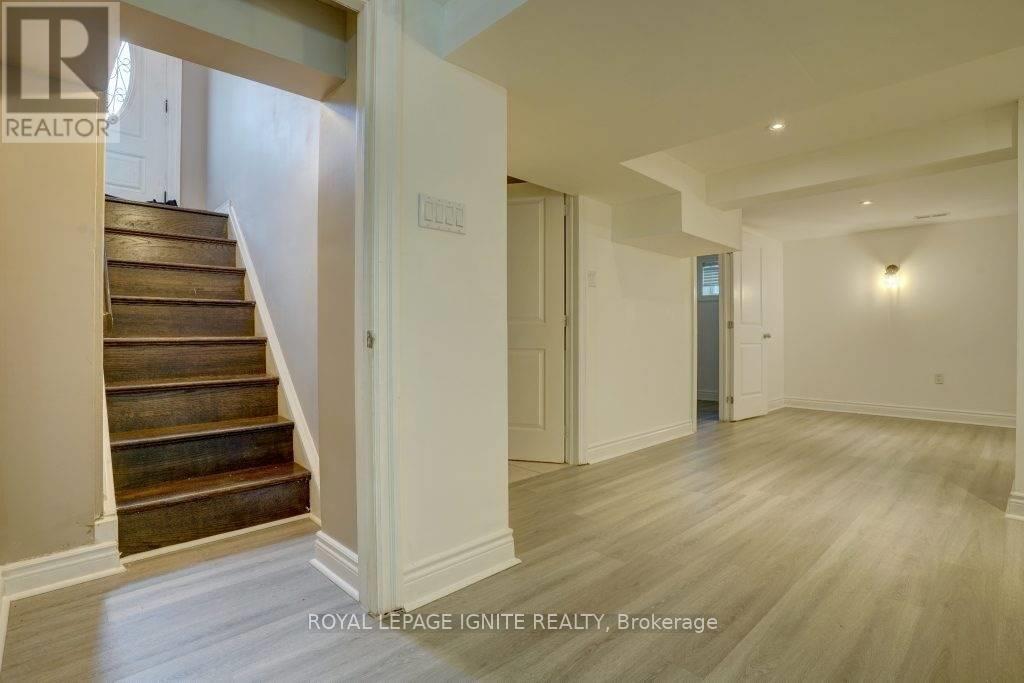 A spacious hallway with wooden floors and a staircase leading to the second floor.