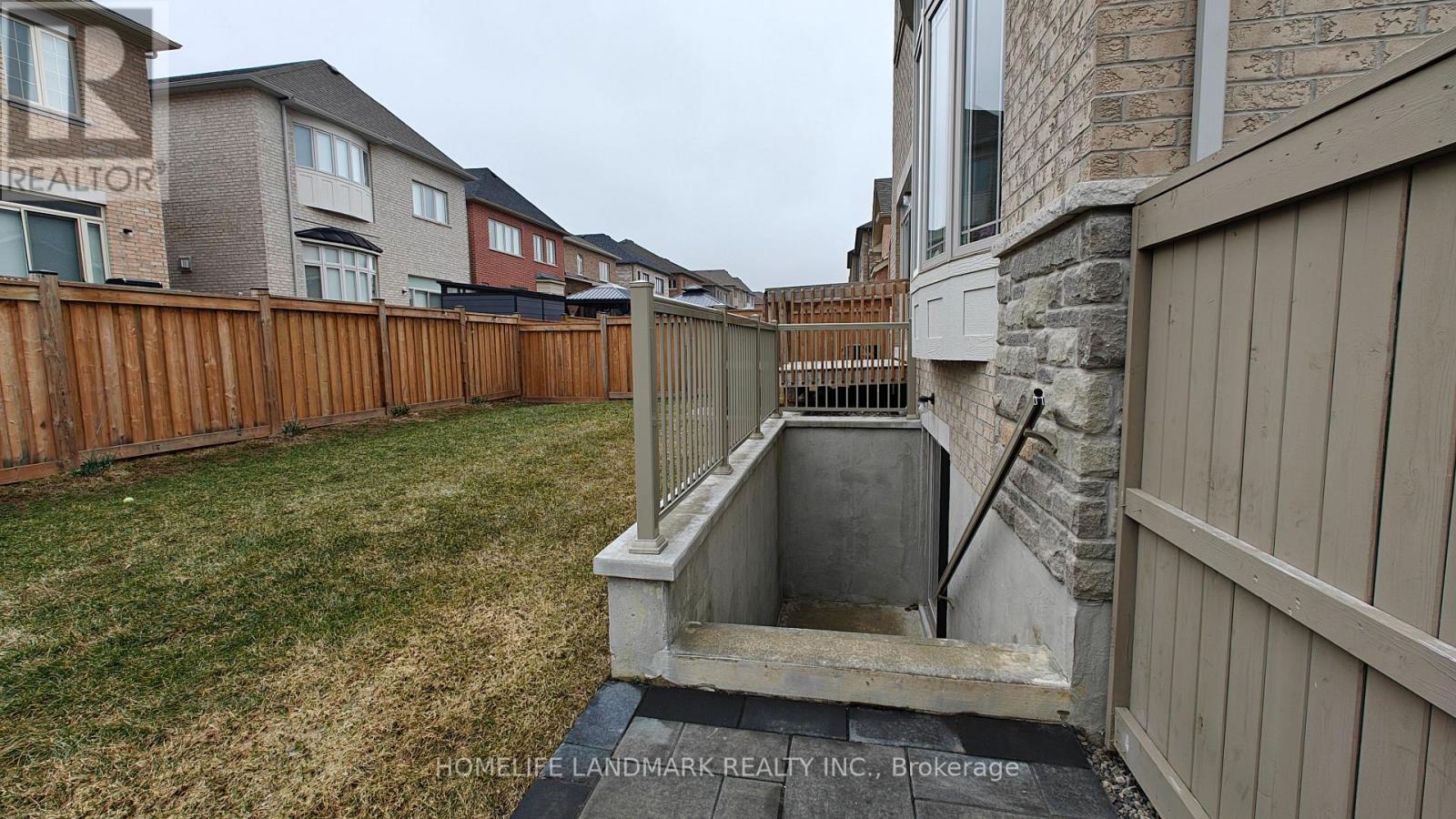 A backyard with a wooden fence and a stone wall.