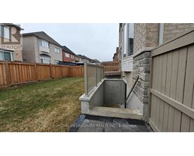 A backyard with a wooden fence and a stone wall.