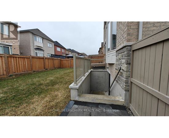 A backyard with a wooden fence and a stone wall.
