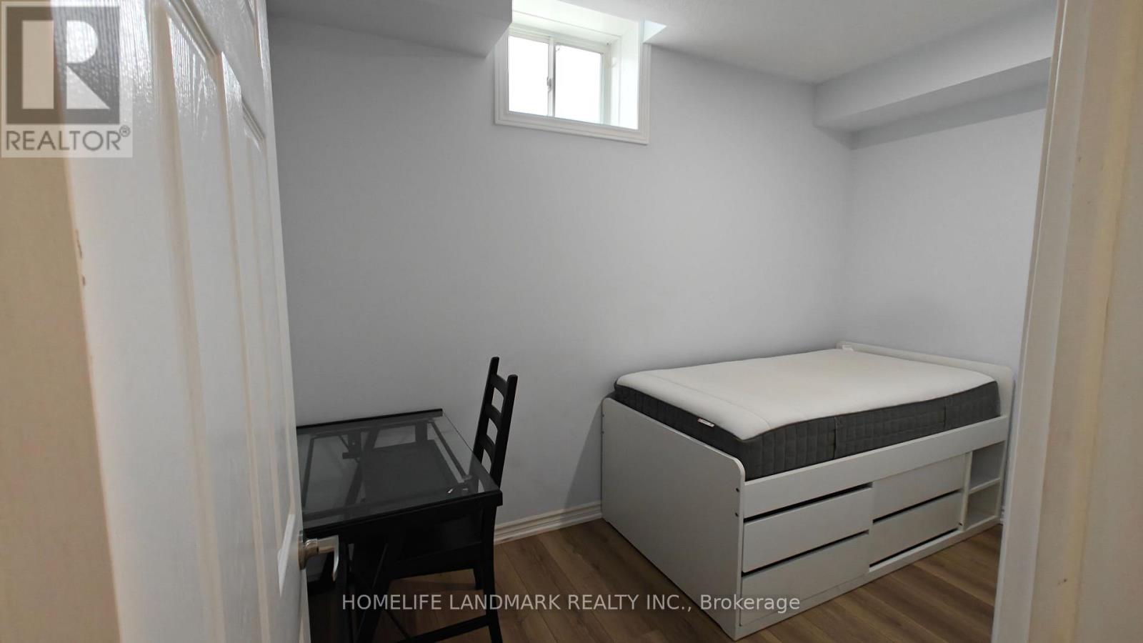 A small bedroom with a bed, chair, and desk.