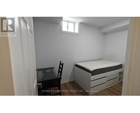 A small bedroom with a bed, chair, and desk.