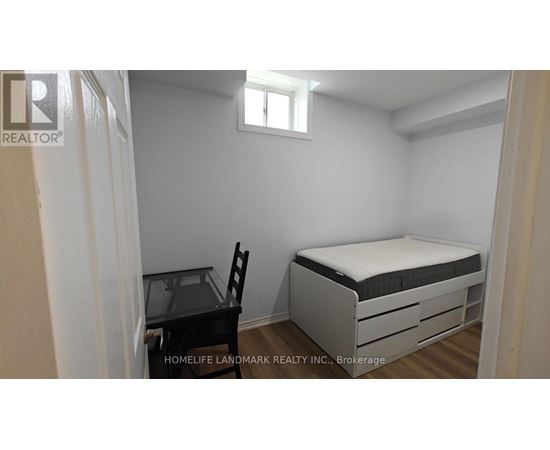 A small bedroom with a bed, chair, and desk.