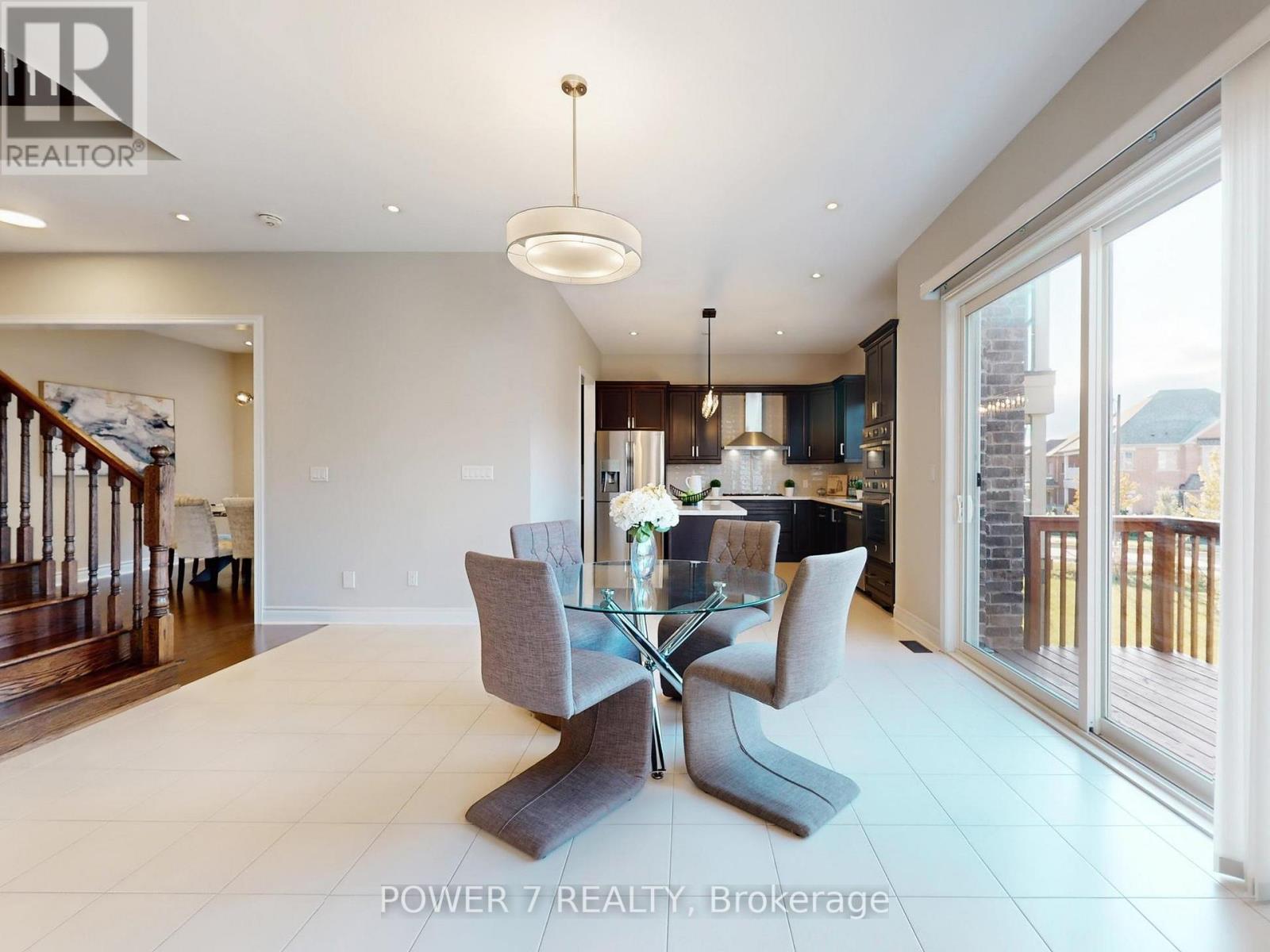 A modern dining room with a glass table and grey chairs.