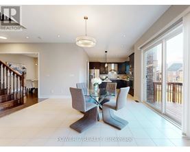 A modern dining room with a glass table and grey chairs.
