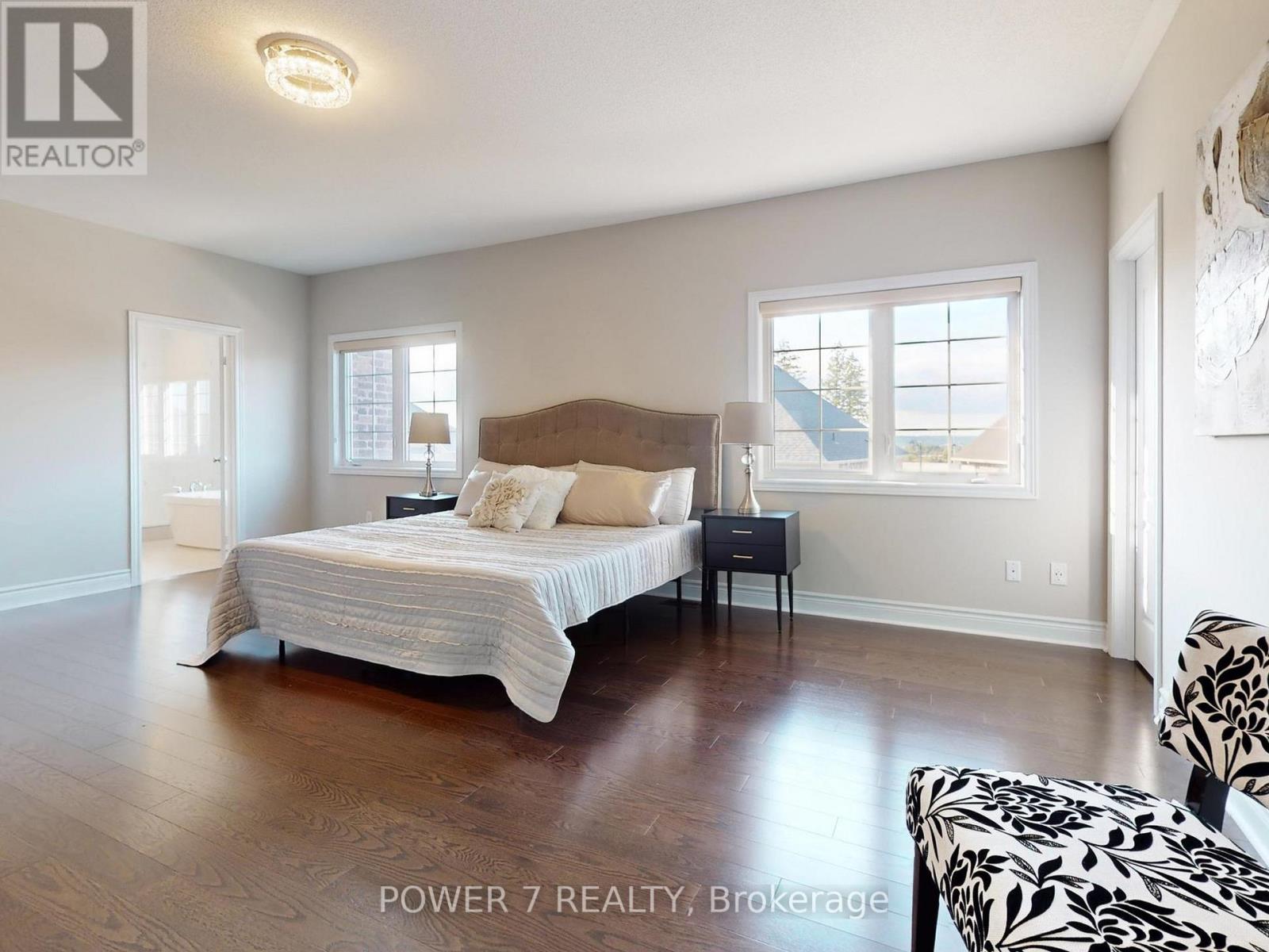 A bedroom with a large bed and a chair.